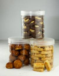 Three transparent plastic jars with white screw-on lids containing assorted cookies and snack products, displayed against a plain background. The containers showcase product visibility and organized food packaging.