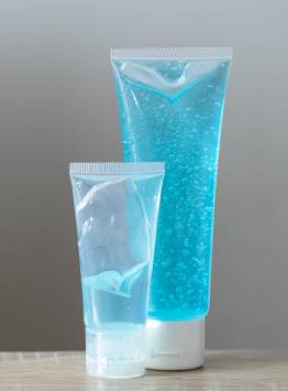 Transparent plastic squeeze tubes filled with blue gel, commonly used for cosmetic and personal care products.