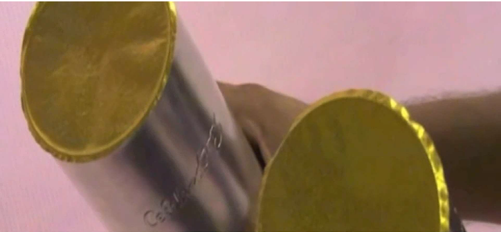 Close-up view of two metal containers sealed with gold-colored induction foil liners, demonstrating tamper-evident packaging protection.
